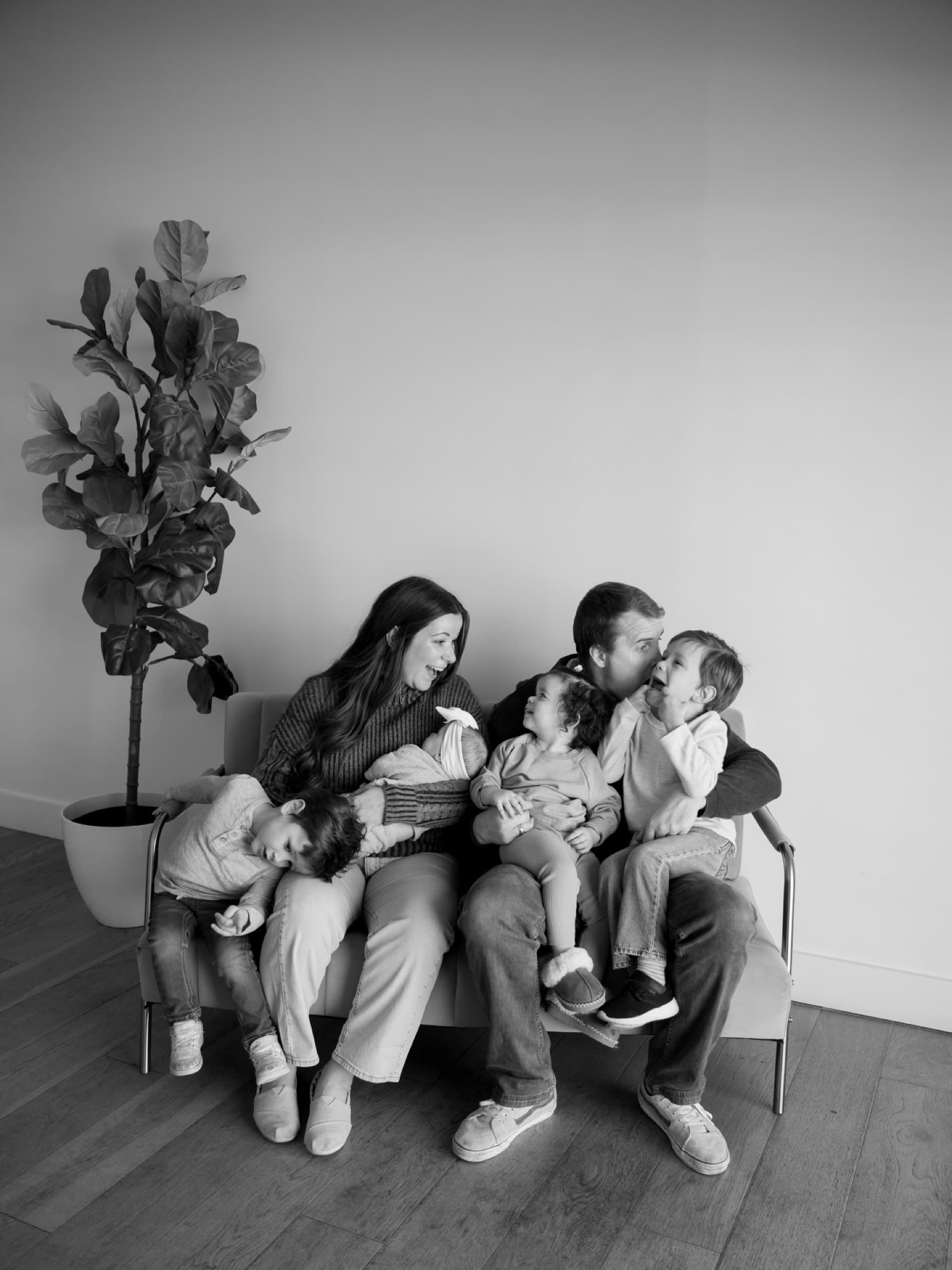 A family sits closely together in a black-and-white portrait.