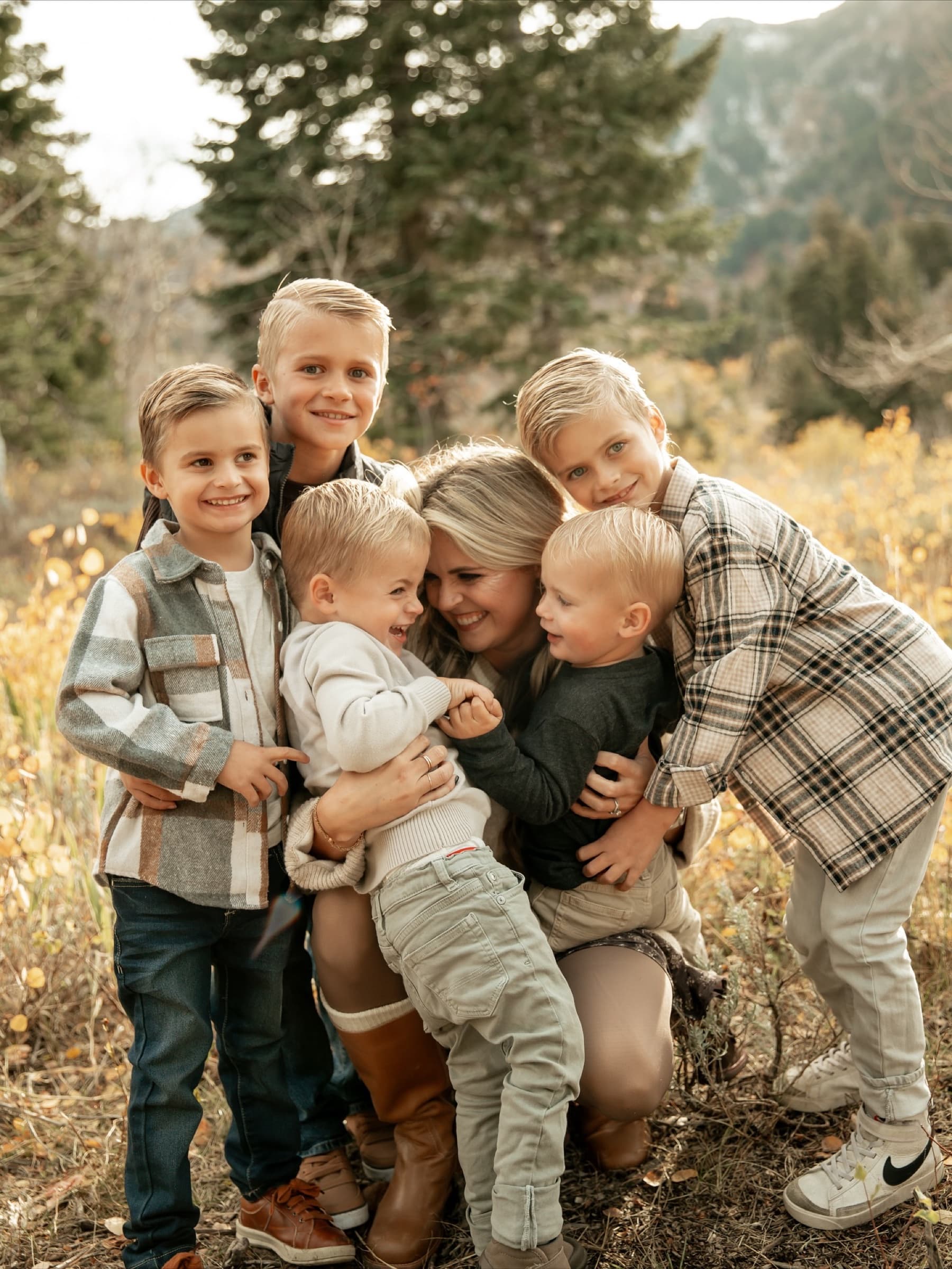Parents and children lean into a close family embrace.